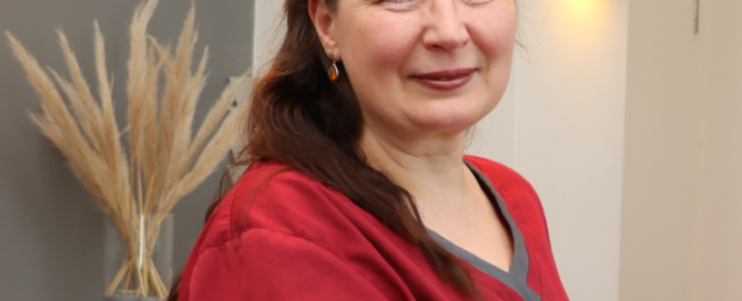 Mitarbeiterin Elena Meisner lehnt an der Theke der Zahnarztpraxis Rhiem.