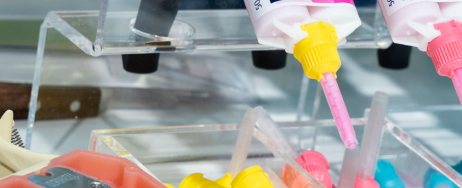 Dentalwerkzeuge, ein Plastik-Gebiss und Füllmaterial auf der IDS 2025 in Nahaufnahme fotografiert.