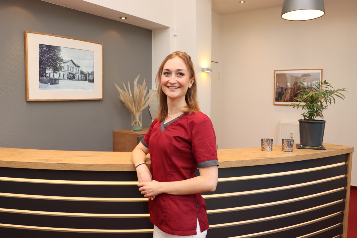 Hauck Carina Hauck lehnt an der Empfangstheke der Praxis für Zahnheilkunde Susanne Rhiem.