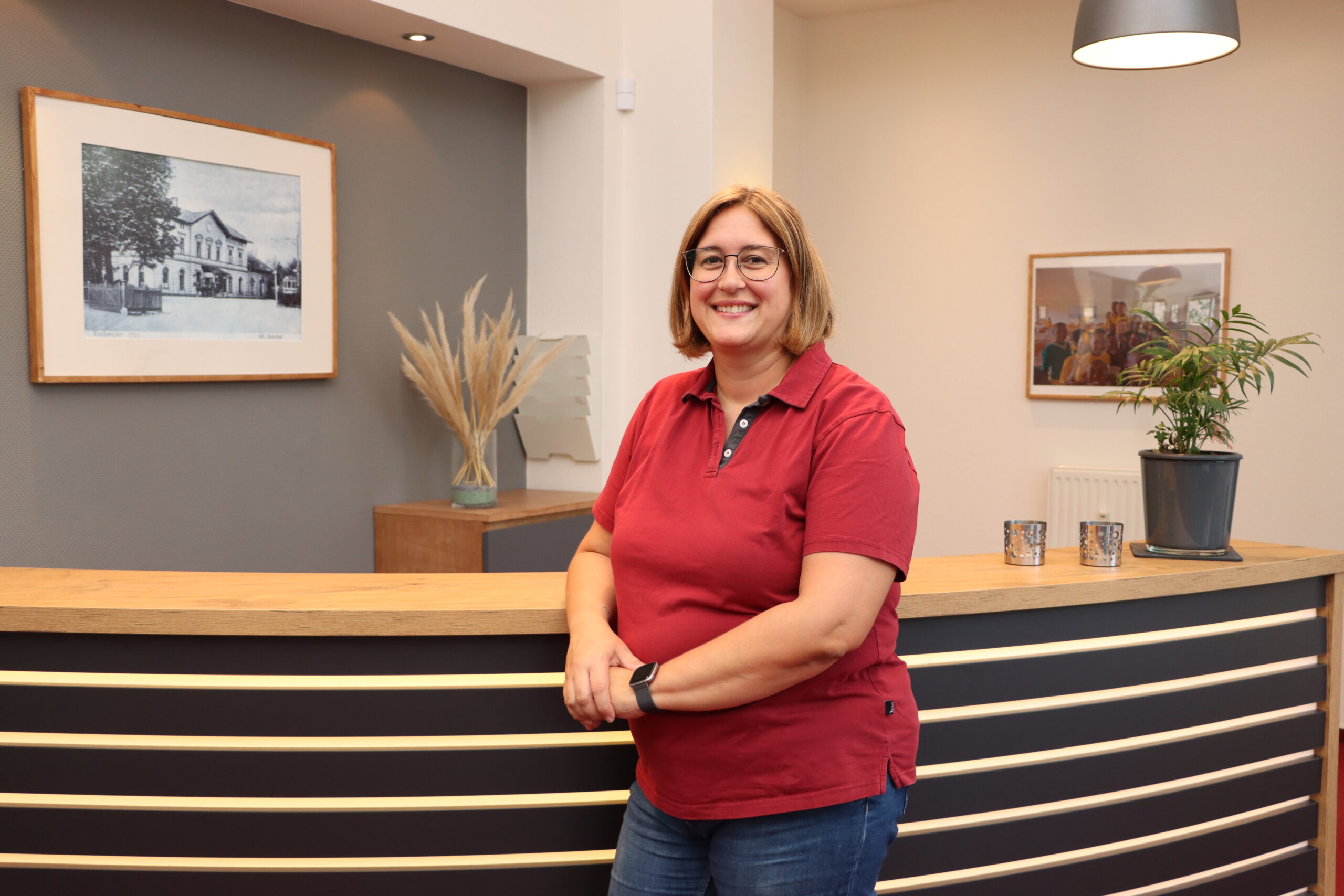 Mock Rezeptionistin Andrea Mock lehnt an ihrem Arbeitsplatz in der Praxis für Zahnheilkunde Susanne Rhiem.