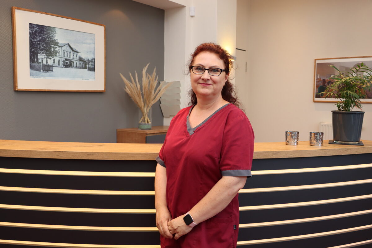 Stehle ZFA Valentina Stehle steht vor der Empfangstheke der Praxis für Zahnheilkunde Susanne Rhiem.
